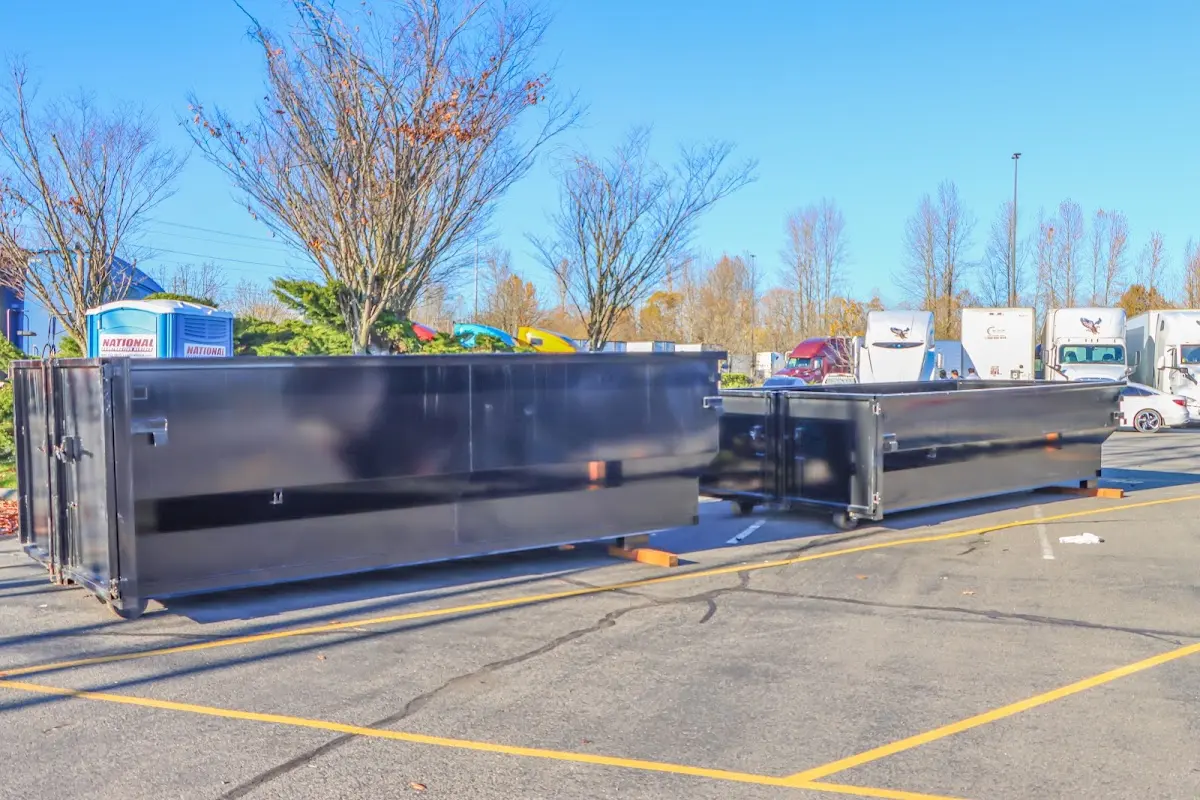 Professional dumpster rental service with roll-off container on residential driveway in Stansbury Park
